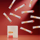 A white rectangular box labeled MegaPWT stands on a red surface, with multiple white single-serve packets floating around it against a red studio background. dōTERRA MetaPWR Recharge Electrolytes (Wild Strawberry)